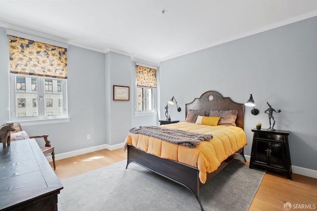 bedroom with baseboards, crown molding, and wood finished floors