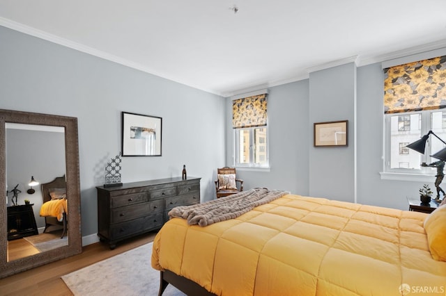 bedroom with wood finished floors and ornamental molding