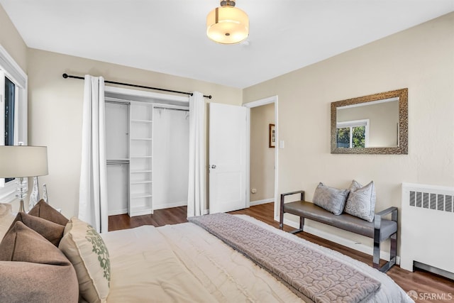 bedroom featuring radiator heating unit, dark wood-type flooring, and a closet