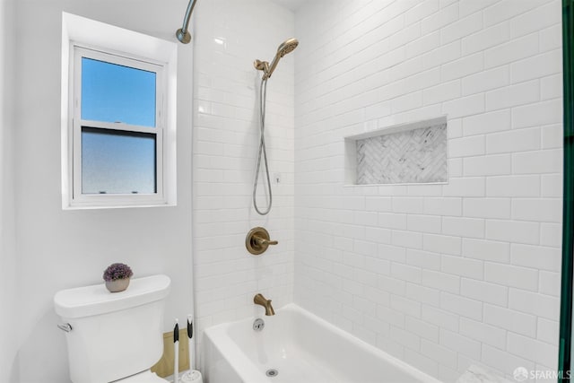 bathroom with tiled shower / bath combo and toilet