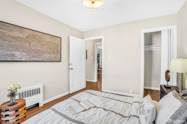 bedroom with radiator, a closet, and hardwood / wood-style floors