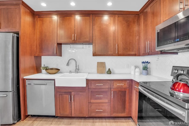 kitchen featuring decorative backsplash, sink, and appliances with stainless steel finishes