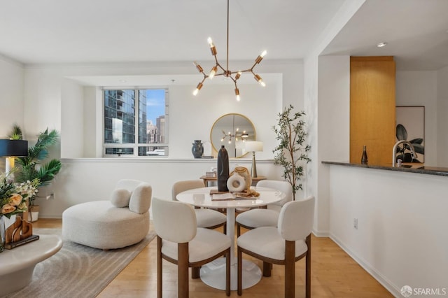 dining room with light hardwood / wood-style flooring, ornamental molding, and an inviting chandelier