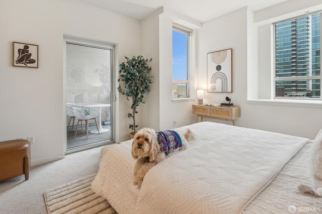 carpeted bedroom with access to outside and ornamental molding