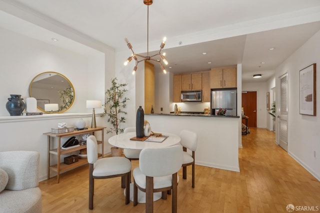 dining room featuring a notable chandelier and light wood-type flooring