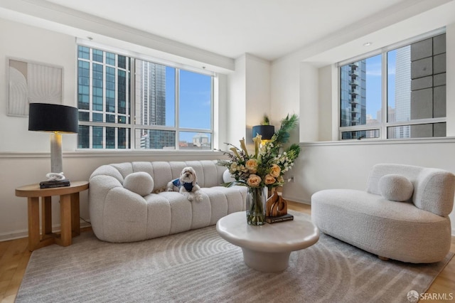 living room with hardwood / wood-style flooring, a wealth of natural light, and ornamental molding