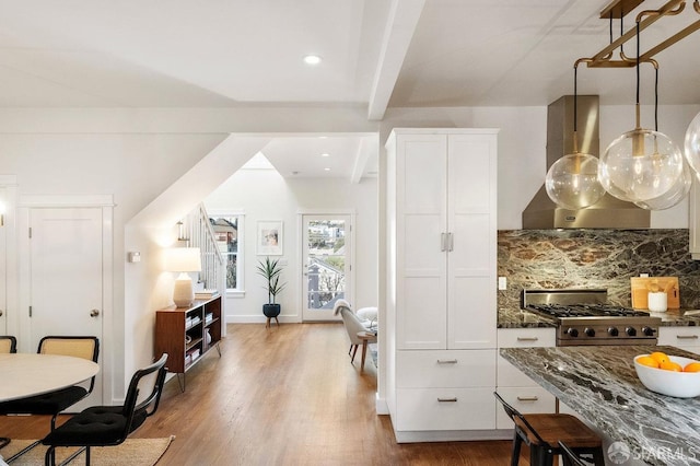 kitchen with island range hood, wood finished floors, white cabinetry, decorative backsplash, and beamed ceiling