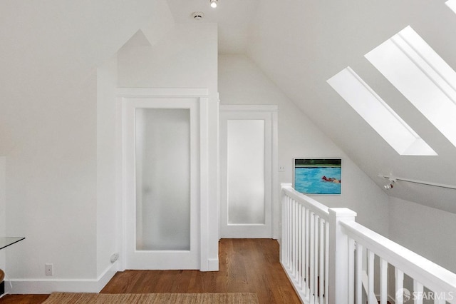 additional living space featuring lofted ceiling with skylight and wood finished floors