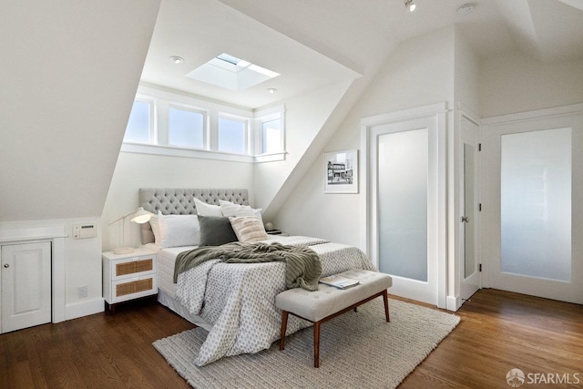 bedroom featuring lofted ceiling with skylight and wood finished floors