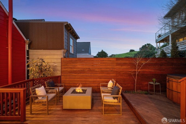 wooden terrace featuring a fire pit and fence