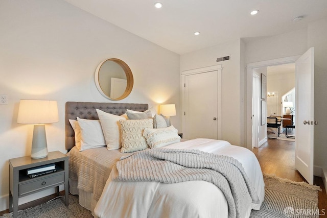 bedroom featuring recessed lighting, visible vents, baseboards, and wood finished floors