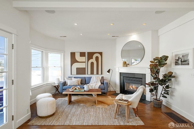 living area featuring baseboards, visible vents, a tiled fireplace, wood finished floors, and recessed lighting