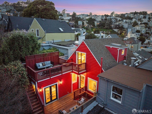 back of property with roof with shingles and a balcony