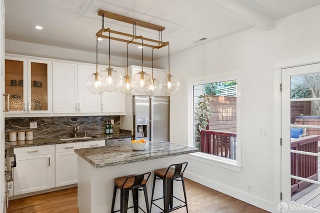 kitchen featuring light wood-style floors, backsplash, a sink, and stainless steel fridge with ice dispenser