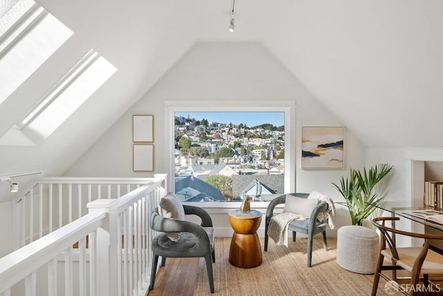 additional living space featuring vaulted ceiling with skylight and wood finished floors