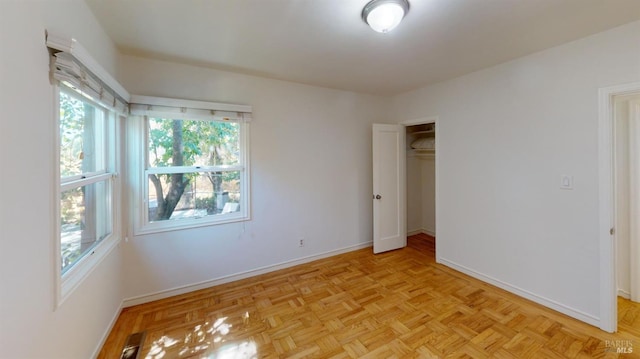 unfurnished bedroom featuring light parquet flooring and a closet