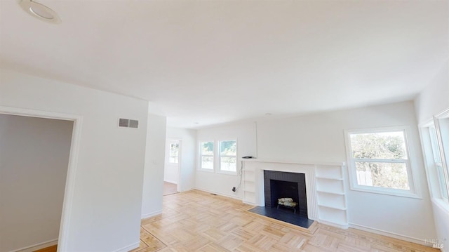 unfurnished living room with light parquet floors and a fireplace