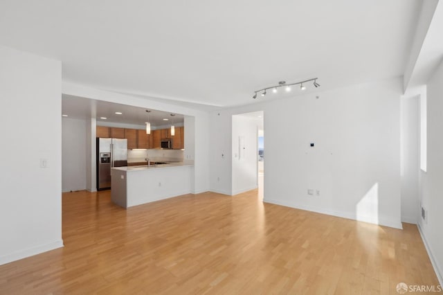 unfurnished living room with light wood-type flooring and sink