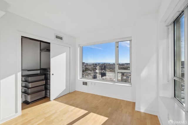 unfurnished bedroom with light hardwood / wood-style flooring and a closet