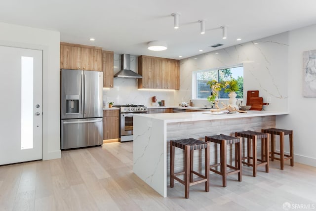 115 Gladeview Way, San Francisco, CA 94131 - kitchen featuring appliances with stainless steel finishes, wall chimney range hood, light wood-style floors, a peninsula, and a kitchen bar