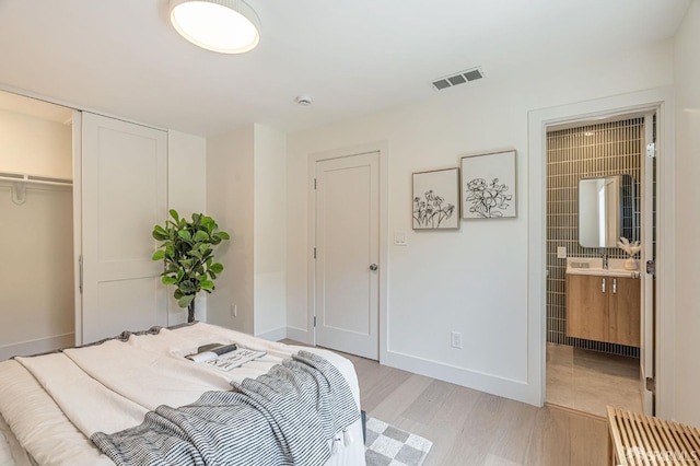 115 Gladeview Way, San Francisco, CA 94131 - bedroom with a closet, light wood-style floors, baseboards, connected bathroom, and a sink