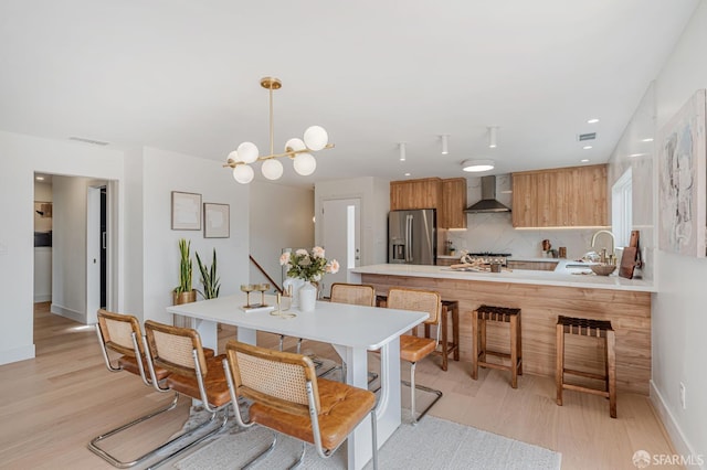 115 Gladeview Way, San Francisco, CA 94131 - kitchen with wall chimney range hood, stainless steel refrigerator with ice dispenser, light wood-style floors, a peninsula, and recessed lighting