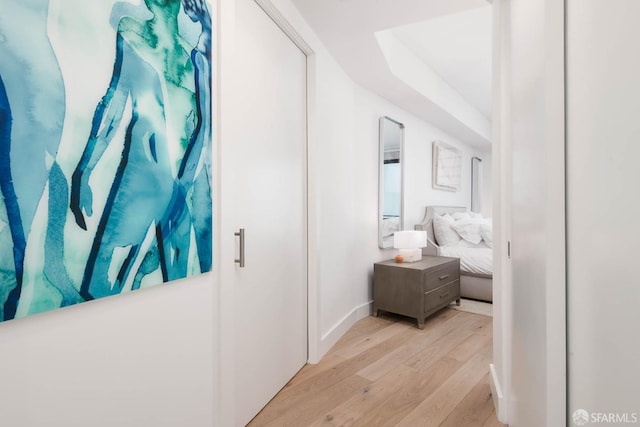hall with light wood-style floors and baseboards