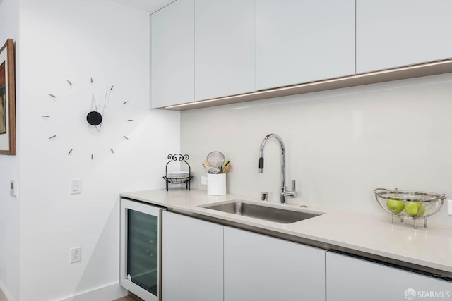 bar featuring a sink, indoor wet bar, and beverage cooler