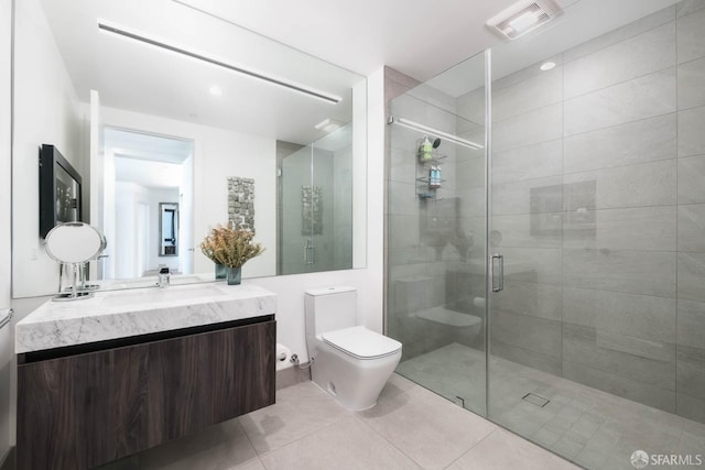 bathroom with toilet, a shower stall, tile patterned flooring, and vanity