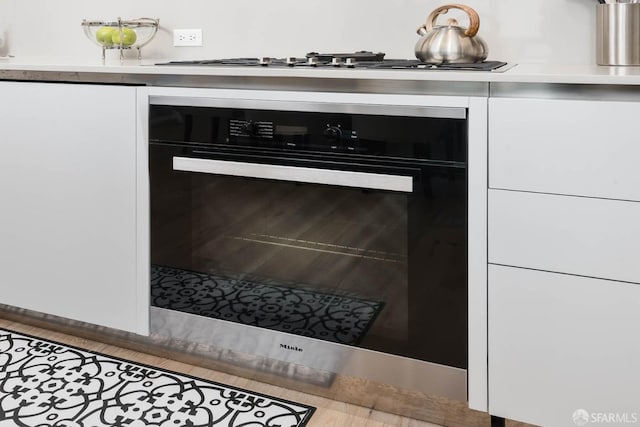 room details with oven, light countertops, white cabinets, and stainless steel gas stovetop