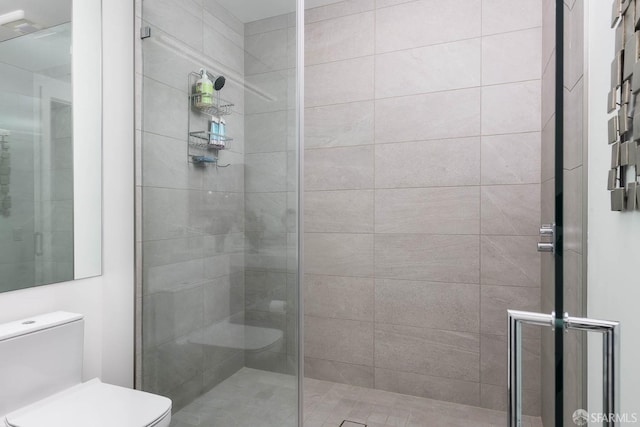 bathroom featuring a shower stall and toilet