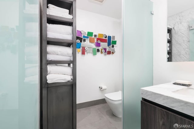 bathroom featuring toilet, tile patterned floors, and vanity