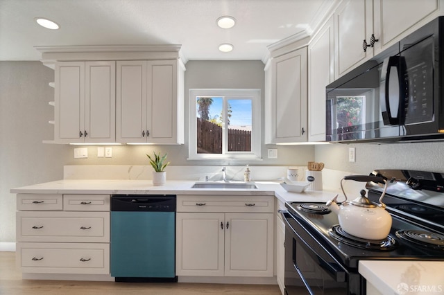 kitchen with appliances with stainless steel finishes, white cabinetry, and sink