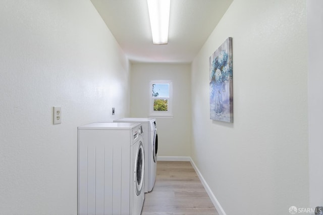 laundry room featuring washer and clothes dryer and light hardwood / wood-style flooring