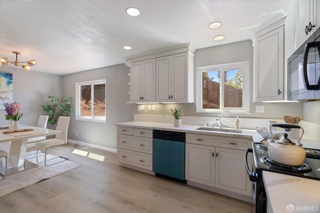 kitchen with stainless steel dishwasher, a wealth of natural light, light hardwood / wood-style flooring, range, and white cabinetry