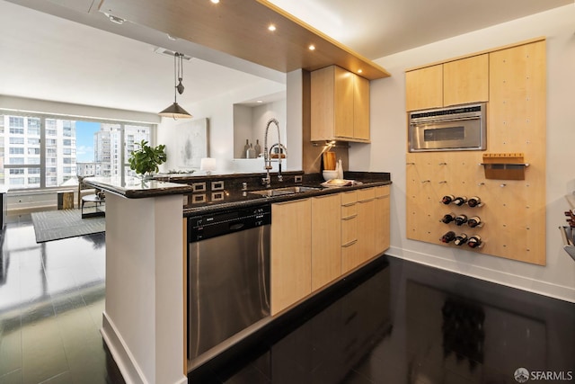 kitchen with appliances with stainless steel finishes, light brown cabinets, a sink, a peninsula, and recessed lighting