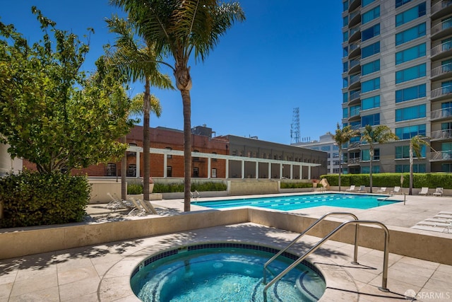 community pool with a hot tub and a patio area