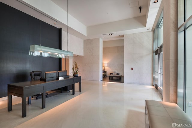 office area with a towering ceiling, tile walls, and recessed lighting