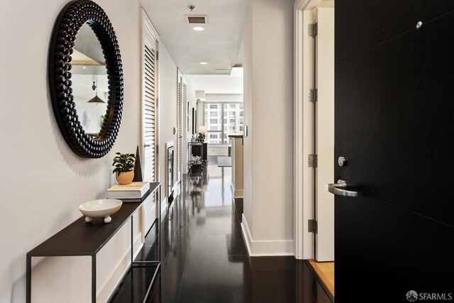 hall with baseboards and recessed lighting