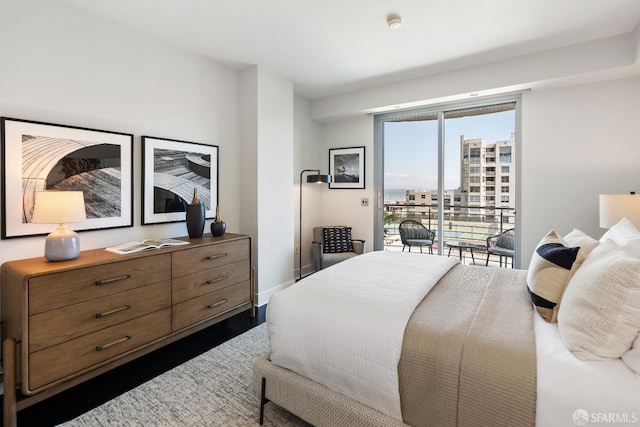 bedroom featuring access to exterior, dark wood-style floors, and baseboards