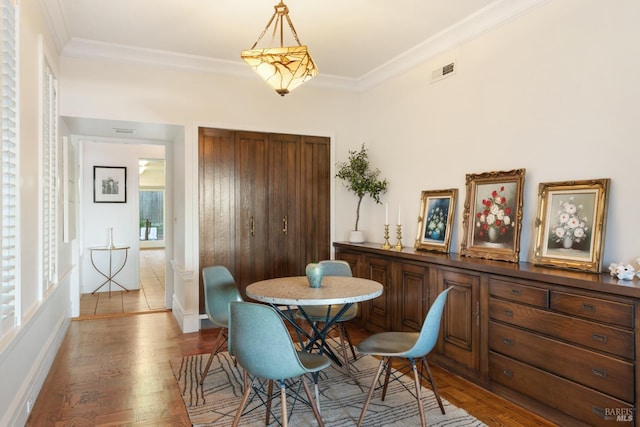 dining room featuring crown molding and light hardwood / wood-style flooring