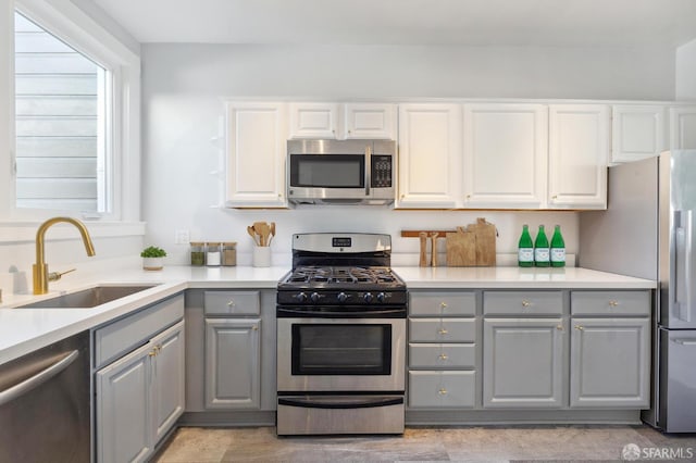1930 Grove St Unit 4, San Francisco, CA 94117 - kitchen with gray cabinetry, stainless steel appliances, white cabinetry, and light countertops