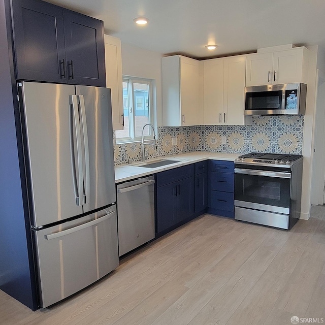 939-9411/2 26th St, Oakland, CA 94601 - kitchen featuring tasteful backsplash, light countertops, a sink, stainless steel appliances, and light wood finished floors