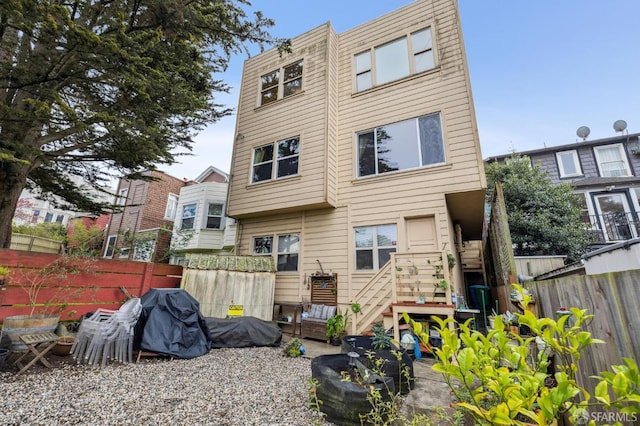 rear view of house with fence and a patio