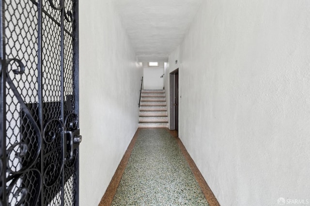 hall featuring stairs and speckled floor