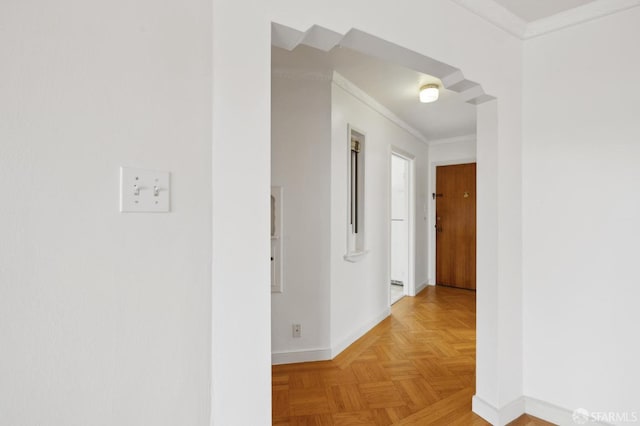 hall with ornamental molding and baseboards