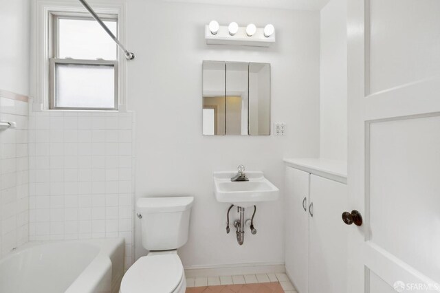 full bath featuring toilet, tile patterned flooring, baseboards, and tub / shower combination