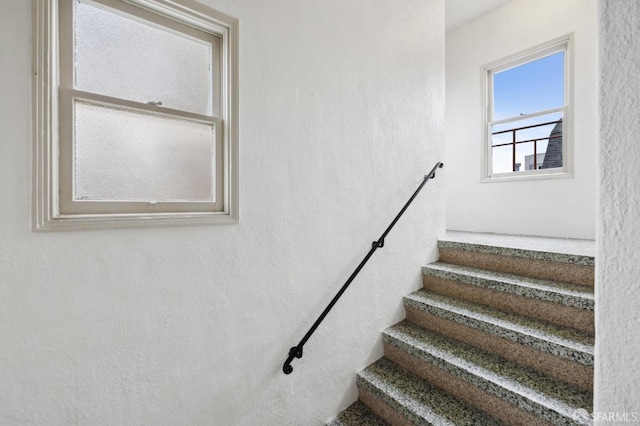 stairway featuring a textured wall