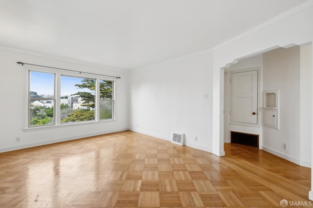 spare room with baseboards, visible vents, and ornamental molding