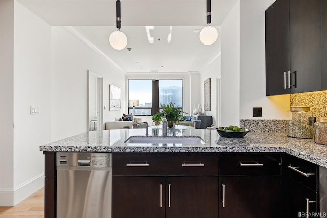 kitchen featuring light stone countertops, sink, light wood-type flooring, and hanging light fixtures